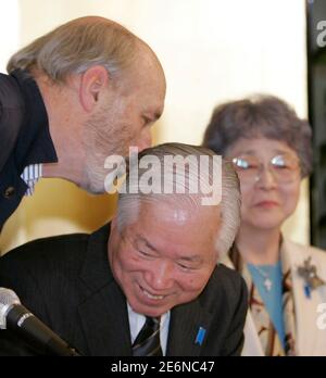 Folk singer Noel Paul Stookey (L) leans over to Shigeru Yokota (C) before singing 'Song for Megumi' at a news conference in Tokyo February 19, 2007.  Shigeru and Sakie Yokota (R) are parents of Japanese abductee Megumi Yokota who disappeared on her way home from school in 1977 at the age of 13.  Megumi Yokota has become the iconic face of Japanese citizens abducted by Pyongyang's agents to help train spies during the 1970s and 1980s.  REUTERS/Kim Kyung-Hoon (JAPAN)