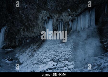 Closeup of icicles covering rock cliff. Ice cave in Slovakia, Waterfall in the national park Mala Fatra, Janosikovy Diery. Cliff with icicles Stock Photo