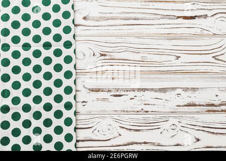 Green polka dot napkin on weathered wooden background Stock Photo