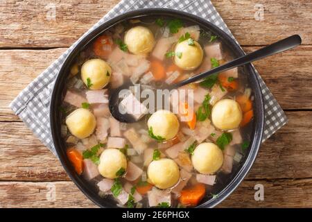 Delicious Liechtenstein cuisine soup with ham and cornmeal dumplings close-up in a plate on the table. horizontal top view from above Stock Photo