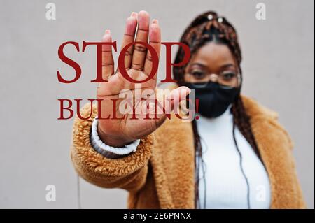 Stop bullying. African american woman, wear black face mask show stop hand sign. Stock Photo