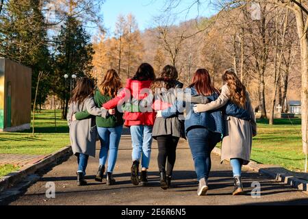 Young group of girls walking in autumn park, autumn clothes and autumn walk. Graduation from high school 2021. Stock Photo