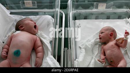 Baby girl Nadia (L), who weighed 7.75 kg (17.1 lbs) after birth, lies in a maternity ward in the Siberian city of Barnaul September 26, 2007. One Siberian mother has done more than her fair share to heal Russia's dire population decline. Tatyana Khalina shocked her husband by giving birth to a 7.75 kg (17.1 lbs) baby girl this month, her 12th child.   REUTERS/Andrey Kasprishin (RUSSIA)