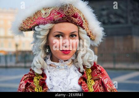 Russian woman in 18th century period dress posing for tourists by the Hermitage Winter Palace on Palace Square in the city Saint Petersburg, Russia Stock Photo