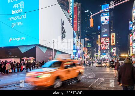 Speeding Taxi in New York City Times Square. Big Animated LED Screens and Toshiba Tower in Background.  Manhattan, New York City, USA Stock Photo