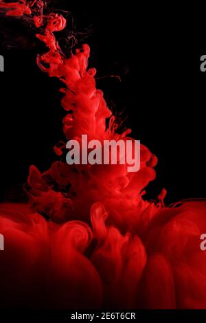 Red abstract background. Ink splashes in water on black Stock Photo