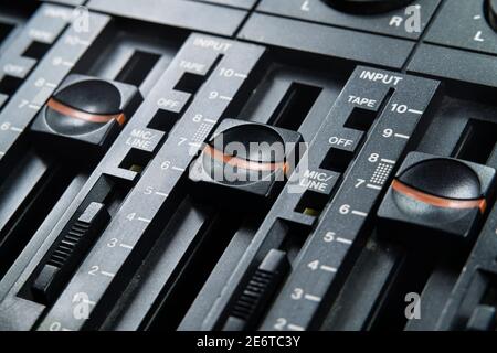 Macro view of volume faders on vintage tape recorder mixing board. Stock Photo