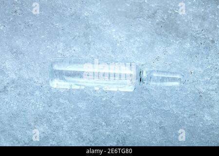 vaccine in a glass transparent ampoule with a medical preparation for the treatment of coronavirus disease chilled for transport temperature lying on Stock Photo