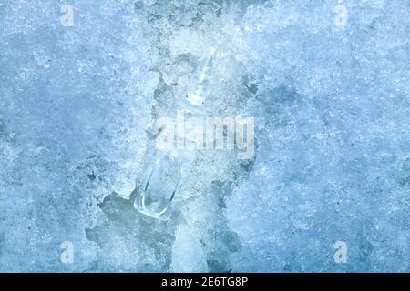 vaccine in a glass transparent ampoule with a medical product for vaccination against coronavirus disease chilled to subzero temperatures lying on col Stock Photo