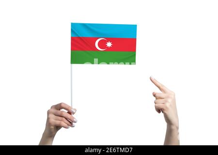 A beautiful female hand holds a Azerbaijan flag to which she shows the finger of her other hand, isolated on white background. Stock Photo