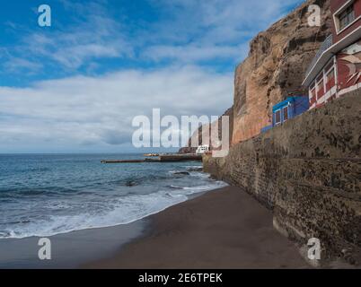 view of village Puerto de Sardina del Norte with sand beach, coastal cliffs, marina and colorful houses. Grand Canaria, Canary islands, Spain Stock Photo