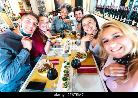 People taking selfie at sushi bar restaurant - New normal lifestyle concept about young friends having fun together at fashion diner Stock Photo