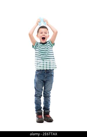 Cute excited kid holding Easter bunny ears hat screaming and looking away fascinated. Full length isolated on white background. Stock Photo