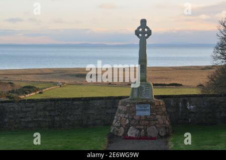 A war memorial cross standing in the church yard of Lothmore and overlooking the Moray Firth on the east coast of Scotland, UK. Stock Photo