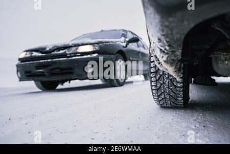 Car tires on winter road covered with snow. Themes safety and driving in winter. Stock Photo