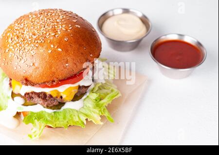 Closeup of big cheeseburger on white in restaurant Stock Photo