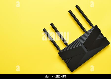 Modern black wi-fi router on a yellow background with copy space Stock Photo