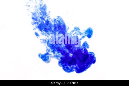 Blue ink injected into water from syringe, colour mixing with water creating abstract shapes Stock Photo