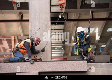 Austin, TX USA, Jan. 12 2021: Construction workers install window panels in a new state office building two blocks north of the Texas Capitol where several new state office buildings are rising. Several state agencies will consolidate their operations into the new building to save on leasing costs and efficiency. ©Bob Daemmrich Stock Photo