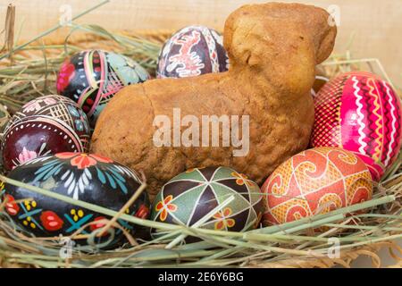 easter lamb cake on hay, easter eggs and willow sticks on wooden table Stock Photo