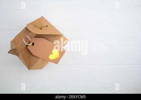 Craft gift box with heart label on white background with space for text. Stock Photo