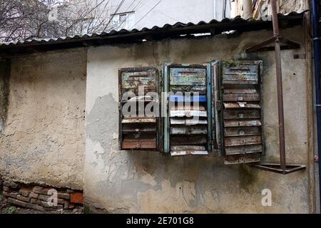 Old rusty mail boxes on the weathered wall. Obsolete broken mailboxes. Stock Photo