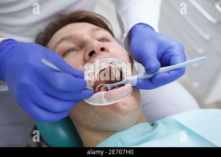 Close up of a man having his teeth examined by professional dentist Stock Photo