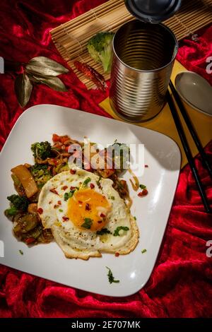 Canned Chinese food chop suey with fried sunny side up egg Stock Photo