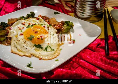 Canned Chinese food chop suey with fried sunny side up egg Stock Photo