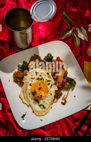 Canned Chinese food chop suey with fried sunny side up egg Stock Photo