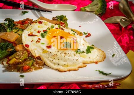 Canned Chinese food chop suey with fried sunny side up egg Stock Photo