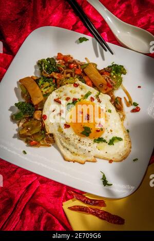 Canned Chinese food chop suey with fried sunny side up egg Stock Photo