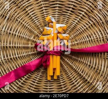 Bunch bouquet of many orange shaving razors tied with pink ribbon at straw natural background, unisex gift Stock Photo