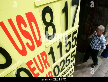 A man passes a foreign currency exchange rate board in Kiev July 30, 2009. The Ukrainian hryvnia currency has fallen in recent weeks, despite the central bank spending its foreign currency reserves, as people demanded to buy the dollar in times of economic uncertainty.   REUTERS/ Konstantin Chernichkin (UKRAINE POLITICS BUSINESS)