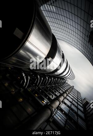 Dramatic long exposure looking up to sky of Lloyds bank building in London city centre chrome and glass skyscraper with modern pipes steel structure Stock Photo