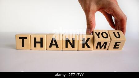 Thank you or me symbol. Businessman turns a cube and changes words 'thank me' to 'thank you'. Beautiful white background, copy space. Business, psycho Stock Photo