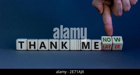 Thank me now or later symbol. Businessman turns cubes and changes words 'thank me later' to 'thank me now'. Beautiful grey background, copy space. Bus Stock Photo