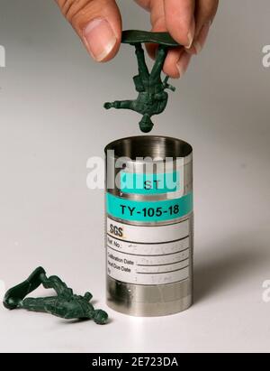 A laboratory staffer from SGS, an inspection, verification, testing and certification company, undergoes a 'small part' test, intended to determine the risk of choking hazard, on toy soldiers in Hong Kong September 13, 2007. The product safety testing business is in overdrive in the wake of a string of high profile recalls of made-in-China toys, including Barbie doll sets by industry giant Mattel Inc recalled earlier this month due to excessive lead in paint.  Picture taken September 13, 2007. To match feature CHINA-QUALITY/TESTING     REUTERS/Bobby Yip  (CHINA)