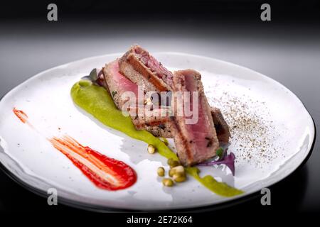 Filet mignon with capers, on a white plate, on a dark background Stock Photo