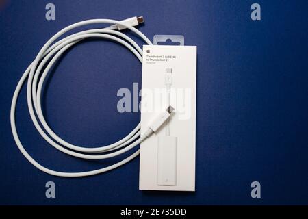 Paris, France - Nov 8, 2018: Overhead view of new unboxed Apple Computers connection Thunderbolt USB-c to Thunderbolt 2 cable to connect old and new peripherals devices computers Stock Photo