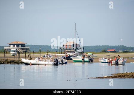 Motorboats moored in front of the Cabanes Thacnquées in the Bassin d'Arcachon, Gironde, France, Europe. There's low tide and boats lay on sand Stock Photo