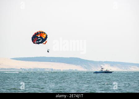 Parasailing in the Atlantic Ocean just in front of the Dune du Pilat, the tallest sand dune in Europe, located in southwestern France Stock Photo