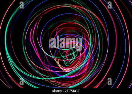 Multi color light painting photography, swirl and curve of blue, green and red light against a black background Stock Photo