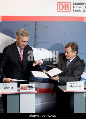 Hartmut Mehdorn (R), chairman of German rail operator Deutsche Bahn, and Peter Loescher, CEO of German engineering conglomerate Siemens, exchange contracts during a news conference in Berlin, December 17, 2008. Deutsche Bahn AG  said on Wednesday they were ordering 15 ICE trains from Siemens AG.    REUTERS/Tobias Schwarz     (GERMANY)