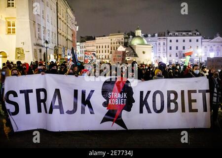 Kracow, Poland. 27th Jan, 2021. Protesters hold placards and a banner with a Women's Strike logo during the demonstration.After the Polish Constitutional Court verdict to implement one of the most restrictive anti-abortion laws in Europe came into effect on January 27th, hundreds of Poles took the streets in all major cities. Protests organized by the by the Women's Strike broke out again after the new anti-abortion bill was finally passed. Credit: SOPA Images Limited/Alamy Live News Stock Photo