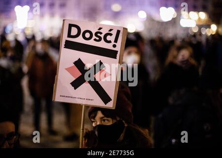 Kracow, Poland. 27th Jan, 2021. A protester wearing a face mask holds a placard saying Enough during the demonstration.After the Polish Constitutional Court verdict to implement one of the most restrictive anti-abortion laws in Europe came into effect on January 27th, hundreds of Poles took the streets in all major cities. Protests organized by the by the Women's Strike broke out again after the new anti-abortion bill was finally passed. Credit: SOPA Images Limited/Alamy Live News Stock Photo