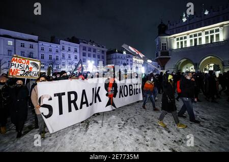 Kracow, Poland. 27th Jan, 2021. Protesters hold placards and a banner with a Women's Strike logo during the demonstration.After the Polish Constitutional Court verdict to implement one of the most restrictive anti-abortion laws in Europe came into effect on January 27th, hundreds of Poles took the streets in all major cities. Protests organized by the by the Women's Strike broke out again after the new anti-abortion bill was finally passed. Credit: SOPA Images Limited/Alamy Live News Stock Photo