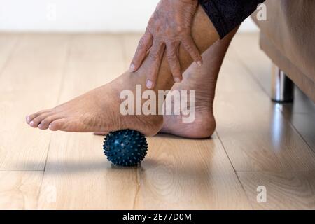 Elderly woman doing rubber ball for exercise fingers, palm ,hand and foot muscle with caregiver take care. Stock Photo