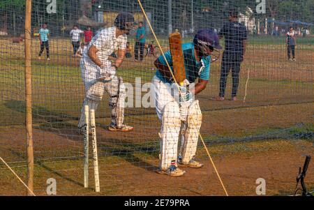 Mumbai, India - December 20, 2020: Unidentified boys practicing batting to improve cricketing skills at Mumbai ground Stock Photo