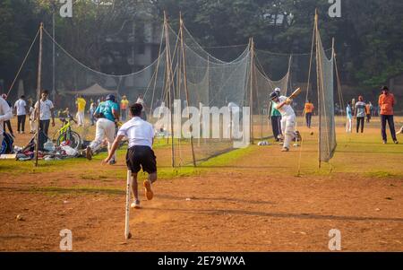 Mumbai, India - December 20, 2020: Unidentified boys practicing batting & bowling to improve cricketing skills at Mumbai ground Stock Photo
